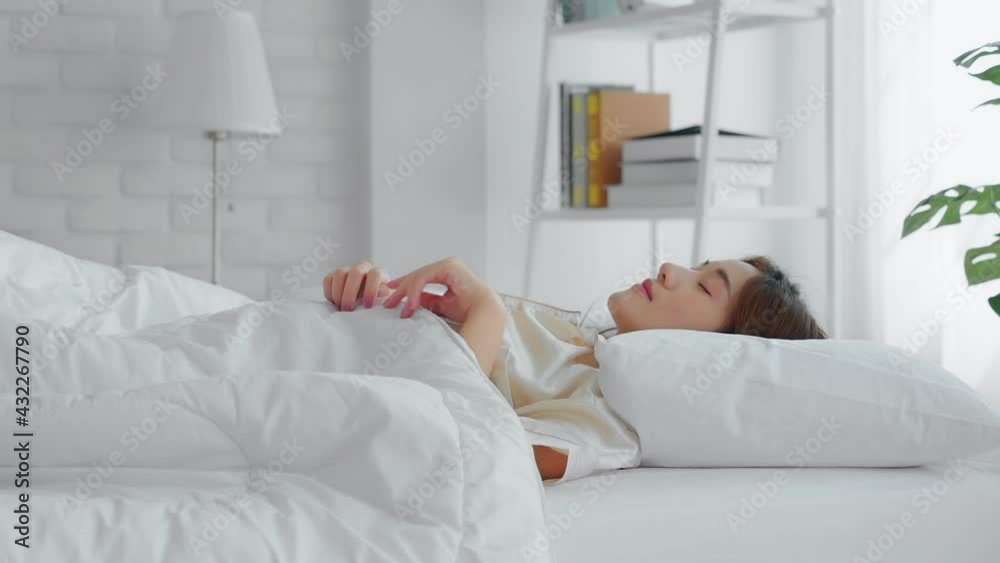 Beautiful woman has good skin sleep comfortably in bed at the morning. She turned from her back to the side and slightly smiled. Rest and health care concept Beautiful woman has good skin sleep comfortably in bed at the morning. She turned from her back to the side and slightly smiled. Rest and health care concept