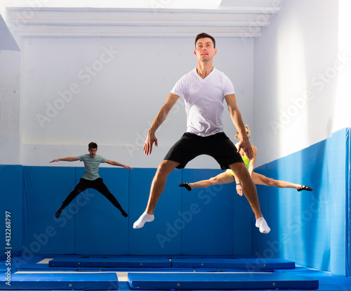 Portrait of scared young man jumping on trampoline in sports center