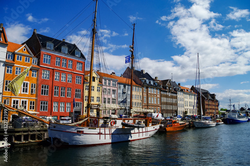 Scenic summer view of Nyhavn pier with old buildings, ships, yachts and other boats in the Old Town of Copenhagen, Denmark