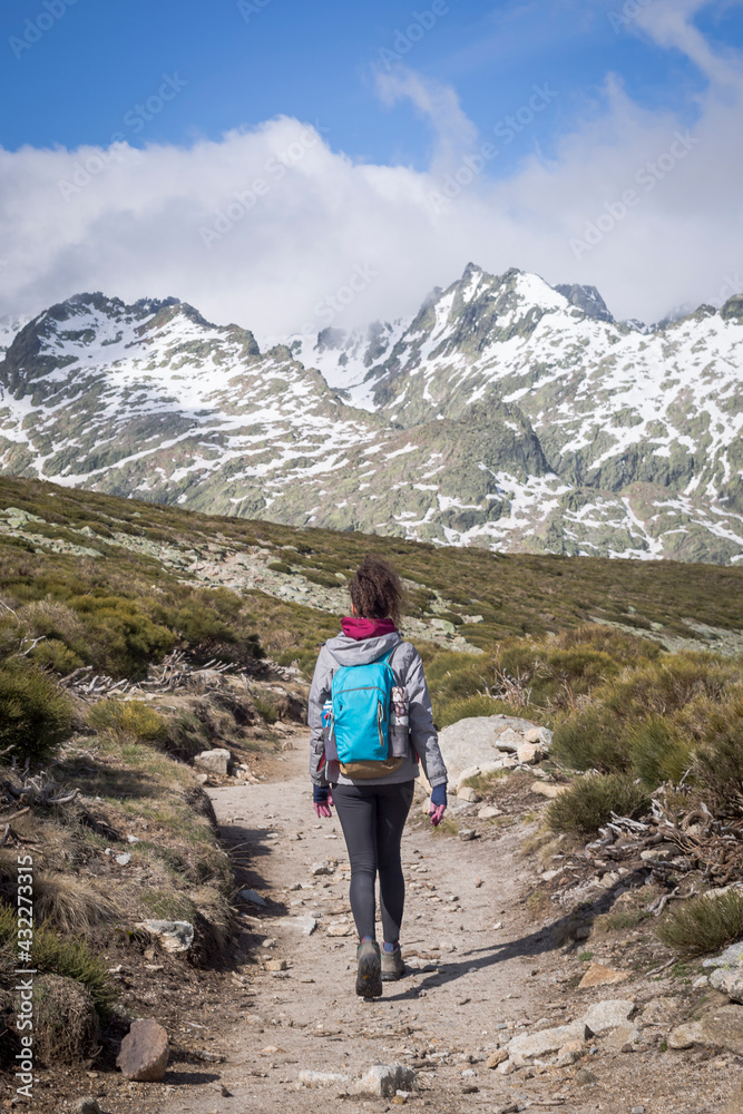 Person with backpack walking down the mountain on a sunny day Person with backpack walking down the mountain on a sunny day