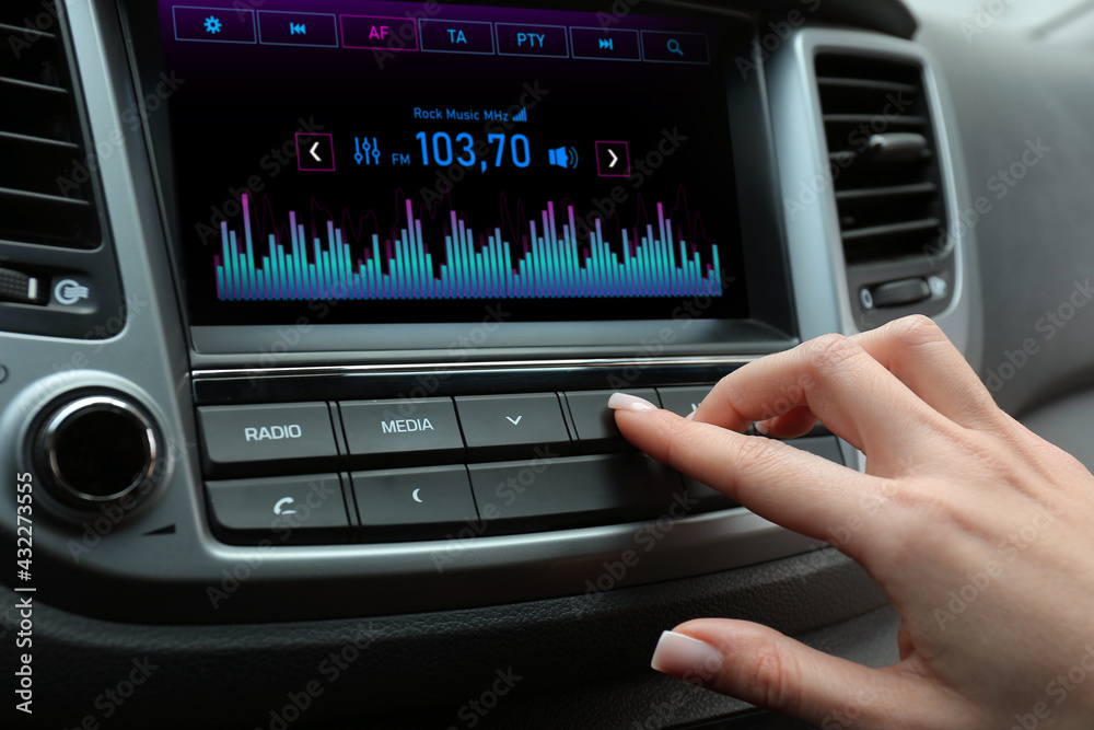 Woman tuning into a radio station in car Woman tuning into a radio station in car