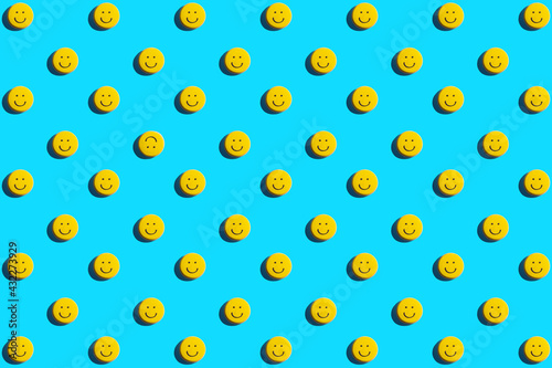Yellow smiley face cookie, food, flat lay, top view, copy space on blue background. Be different.