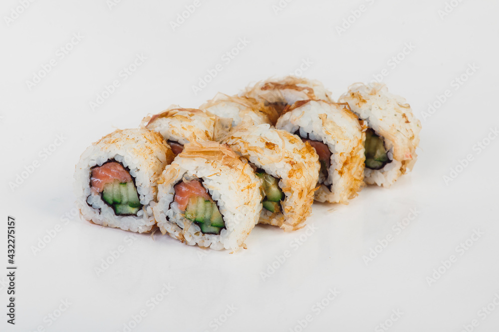 Set of sushi rolls with salmon, cucumber and cream cheese covered with tuna shavings isolated on white background. 