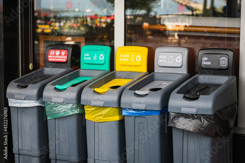 Obraz na plátně There are five trash cans on the street: red for masks, green for glass, yellow for plastic and packaging, gray for metal, and black for residual waste