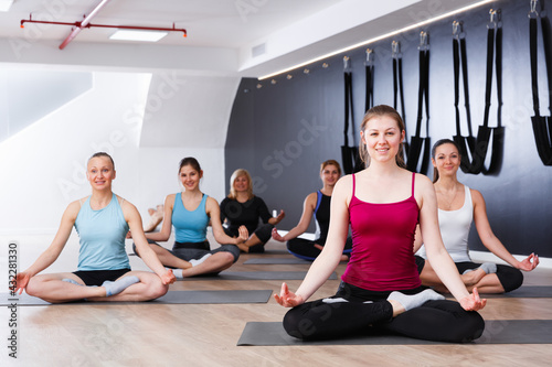 Women making yoga meditation in lotus pose in fitness center
