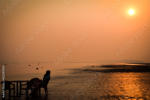 Man sitting sunset at the beach