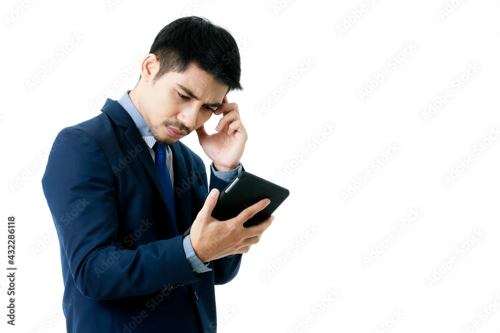 Portrait of serious young Asian businessman in thinking pose while checking company strategy on tablet on isolated white background. Studio shot, business planning concept. Portrait of serious young Asian businessman in thinking pose while checking company strategy on tablet on isolated white background. Studio shot, business planning concept.