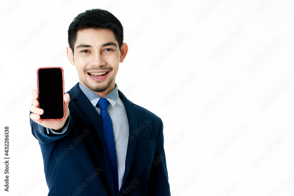 Happy smiling young Asian businessman shows smartphone with blank screen on isolated white background. Studio shot, business communication concept. Happy smiling young Asian businessman shows smartphone with blank screen on isolated white background. Studio shot, business communication concept.