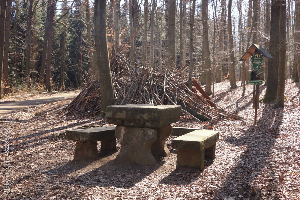 Rock table and chair in the forest background. Large nature stone table and bench in the park Rock table and chair in the forest background. Large nature stone table and bench in the park