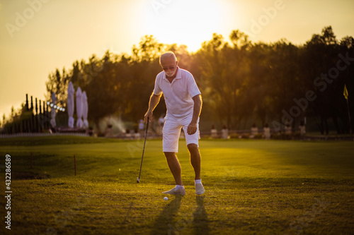 Senior golf player on green with copy space.