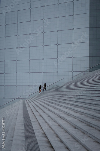 Personnes en pause dans le quartier d'affaire sur les escalier de la Défense, grand espace et lignes de perspectives