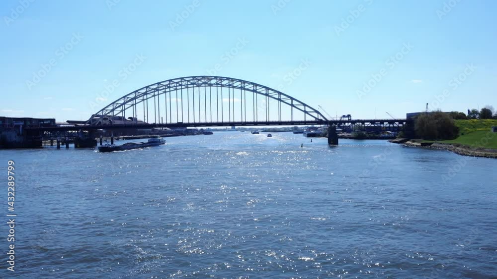 Arch Bridge Over Noord River With Sailing Barge At Daytime In Hendrik-Ido-Ambacht, Netherlands. - aerial Arch Bridge Over Noord River With Sailing Barge At Daytime In Hendrik-Ido-Ambacht, Netherlands. - aerial