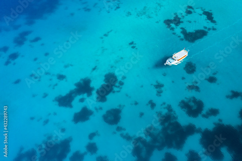 Aerial view of a boat in the blue sea. Yachting, luxury vacation at sea.