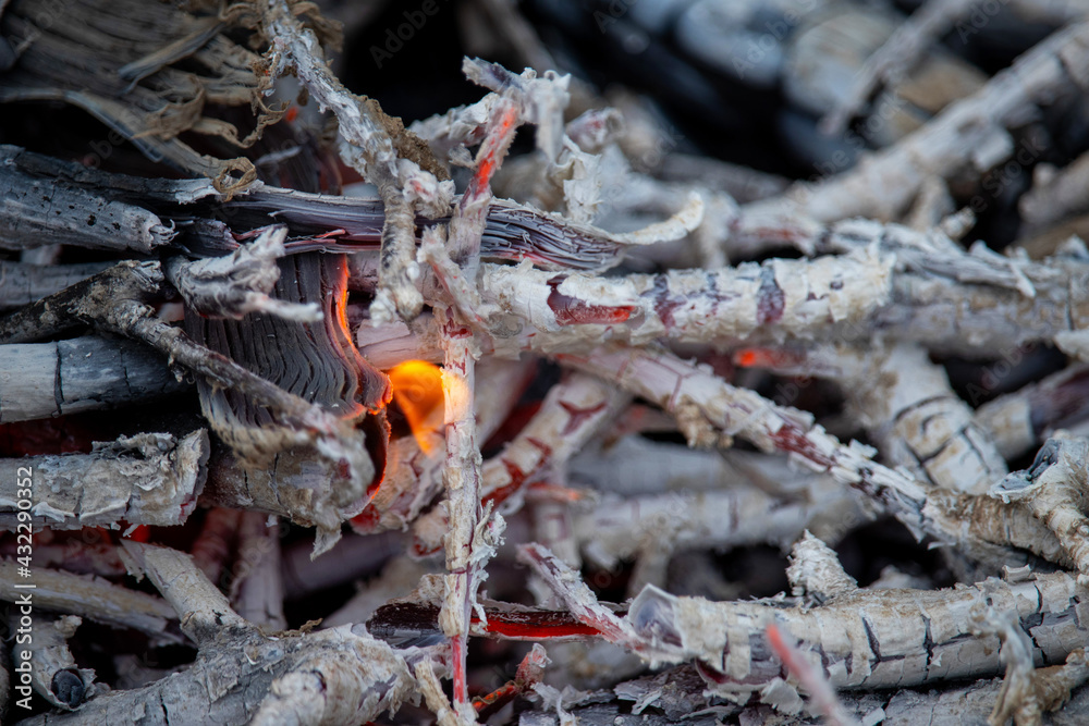 Coals left over from the fire. Gray ash. Fiery tongues. Fire background. Copy space. Close up. Coals left over from the fire. Gray ash. Fiery tongues. Fire background. Copy space. Close up.