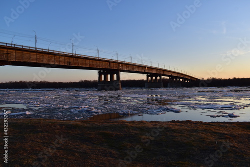 Wallpaper Mural Beautiful evening landscape at sunset with a view of the bridge over the river during the spring ice drift. Torontodigital.ca
