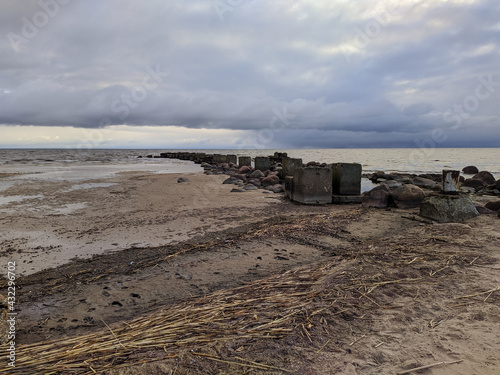 ruined and old sea pier in the evening in spring against the background of the sea and sky