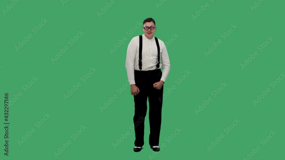 Portrait of a shy man dancing on a green screen. A man in glasses with thick lenses, a white shirt with a suspender poses in the studio. Slow motion. Portrait of a shy man dancing on a green screen. A man in glasses with thick lenses, a white shirt with a suspender poses in the studio. Slow motion.