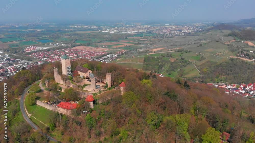 Beautiful top view of the Starkenburg castle in the German city of Heppenheim. The castle is high on the mountain. Mountains and the blue sky in the background. Tiled roofs of houses. Beautiful top view of the Starkenburg castle in the German city of Heppenheim. The castle is high on the mountain. Mountains and the blue sky in the background. Tiled roofs of houses.