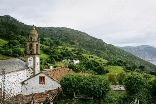 Rural landscape with an old church in the foreground and with the coast in the background