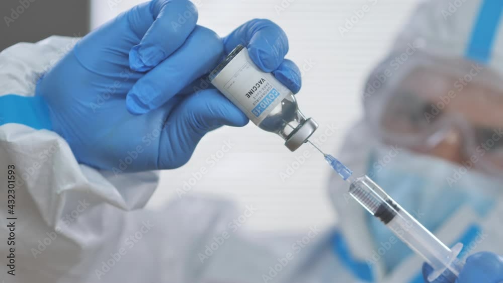 doctor filling syringe with covid-19 vaccine,medic wearing protective suit mask and gloves prepares coronavirus vaccination dose close up front view,hospital clinic interior doctor filling syringe with covid-19 vaccine,medic wearing protective suit mask and gloves prepares coronavirus vaccination dose close up front view,hospital clinic interior