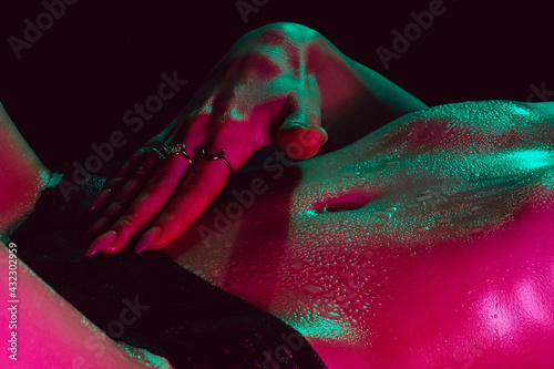 girl with a sexy body erotically touches herself. Female beautiful figure in wet drops