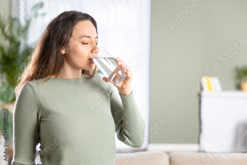 Woman drinking water at home