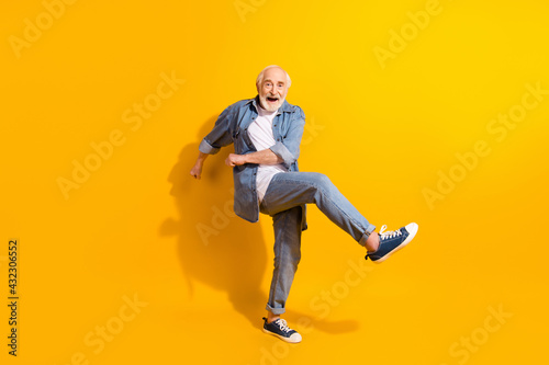 Fototapeta Naklejka Na Ścianę i Meble -  Full length body size view of attractive man dancing fooling having fun isolated over vivid yellow color background