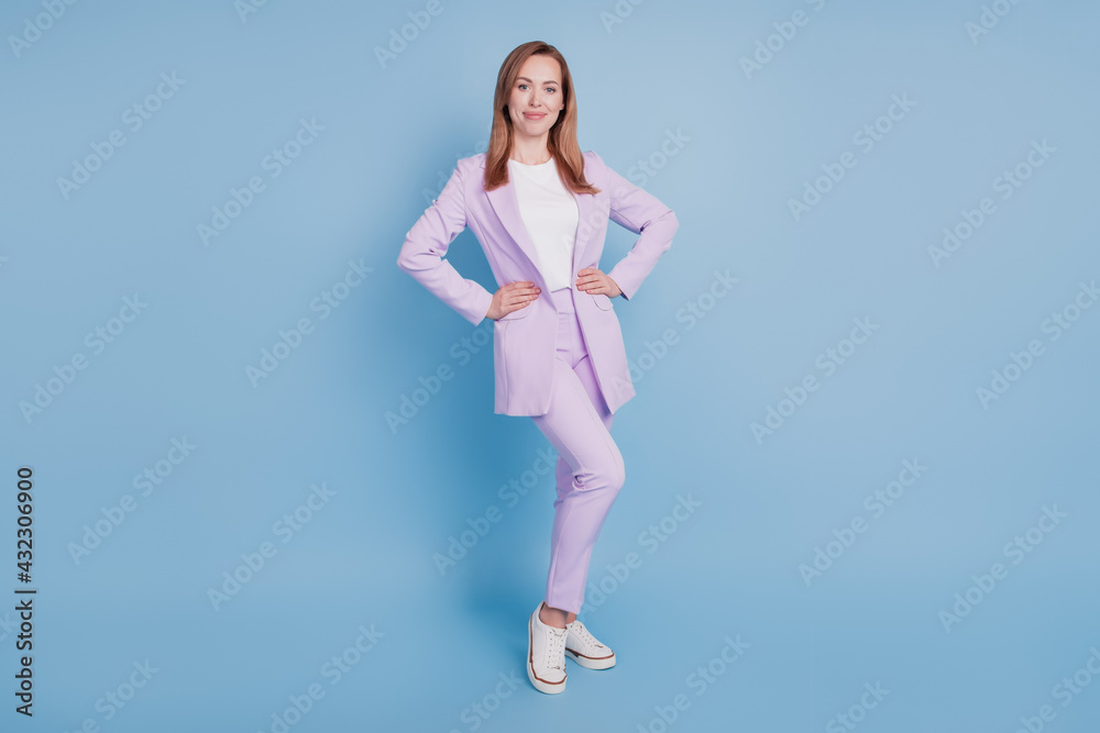 Photo of young executive woman hold hands waist isolated over blue background Photo of young executive woman hold hands waist isolated over blue background