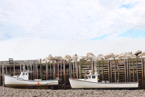two fishing boats sitting on the bottom at low tide in the bay of fundy