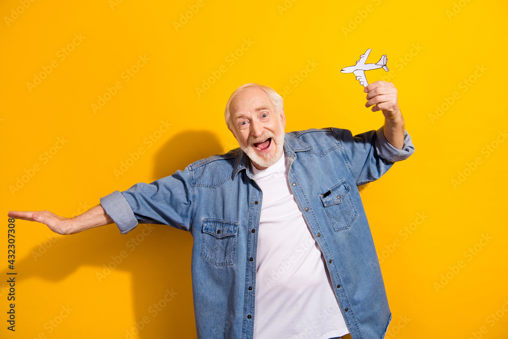 Photo portrait of elder man showing paper plane dreaming about trip on lockdown isolated bright yellow color background