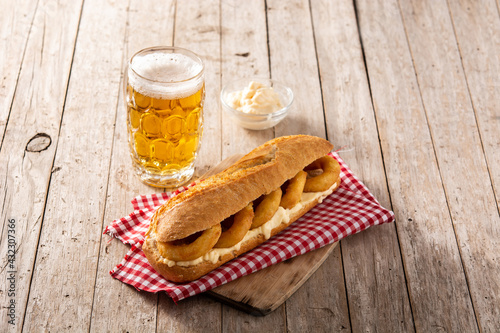 Calamari rings sandwich with beer on wooden table. Typica spanish food	 photo