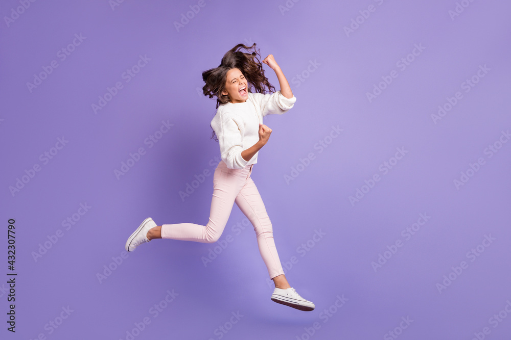 Full body photo of young girl happy rejoice jump run fists hands scream celebrate win victory isolated over purple color background