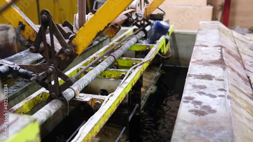 The process of immersing small parts in an electroplating bath. Barrels of metal rotate in an electroplating bath. photo