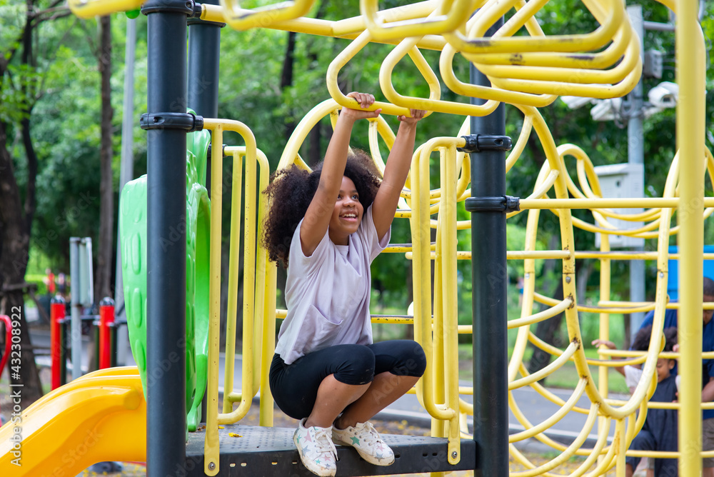 Happy mixed race family in park. Adorable child girl kid playing and  hanging on jungle gym at children playground. Little daughter enjoy and  having fun outdoor lifestyle weekend activity in summer. Photos