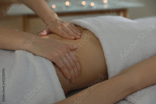 Woman receiving professional belly massage in wellness center, closeup
