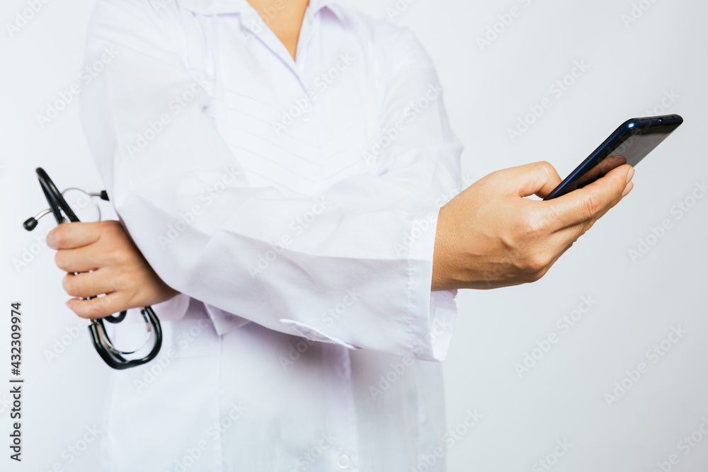Cropped image of smartphone in the hands of a doctor with stethoscope. Cropped image of smartphone in the hands of a doctor with stethoscope.
