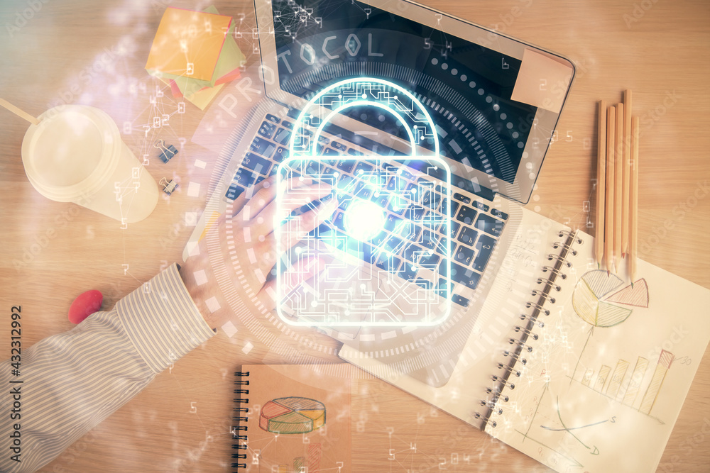 Multi exposure of man's hands typing over computer keyboard and lock hologram drawing. Top view. Technology concept. Multi exposure of man's hands typing over computer keyboard and lock hologram drawing. Top view. Technology concept.