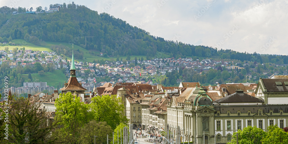 Panoramic view of Bern with mountain and tiled roofs on a sunny day, Switzerland