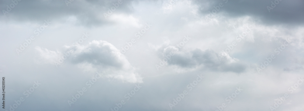Monochromatic panorama with well defined cumulus clouds with soft ephemeral tones and shadow casts. Weather conditions and climate concept. Cinematic sky scenery.