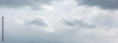 Monochromatic panorama with well defined cumulus clouds with soft ephemeral tones and shadow casts. Weather conditions and climate concept. Cinematic sky scenery.