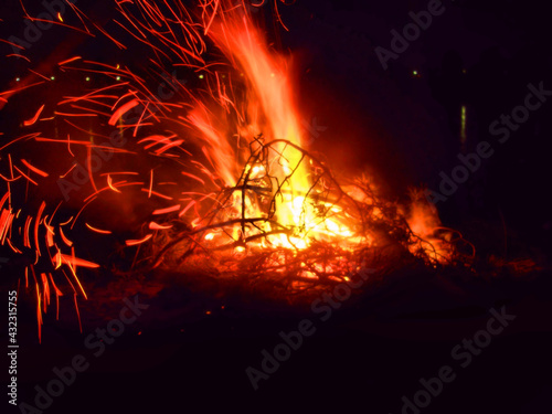 Motion blur of sparkles of campfire with firewood on dark night  background © ElenaEmiliya
