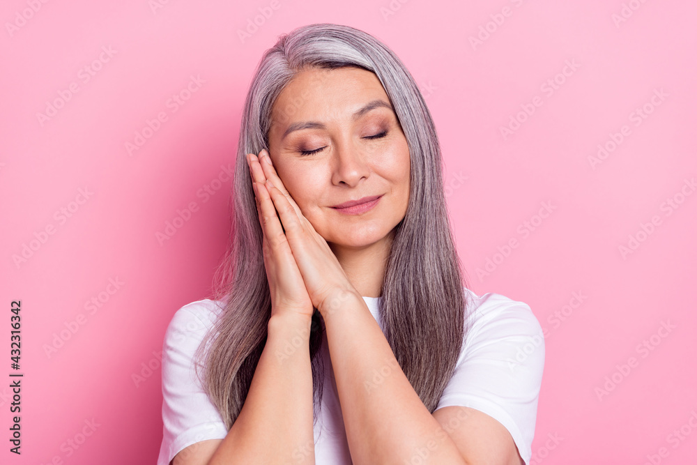 Photo portrait of grandmother with grey hair tired sleeping isolated on pastel pink color background Photo portrait of grandmother with grey hair tired sleeping isolated on pastel pink color background