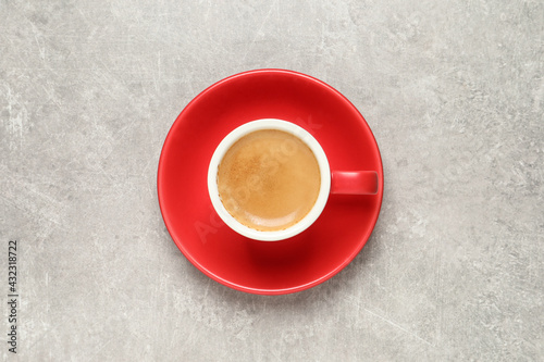 Aromatic coffee in red cup on light grey background, top view