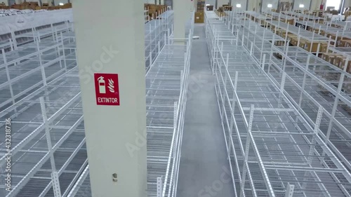 air flight over empty metal shelves in a logistics warehouse