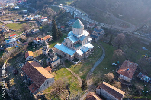 Aerial view of architectural complex of Gelati Monastery with three churches, free standing bell tower and academy building located near Kutaisi on spring day, Georgia