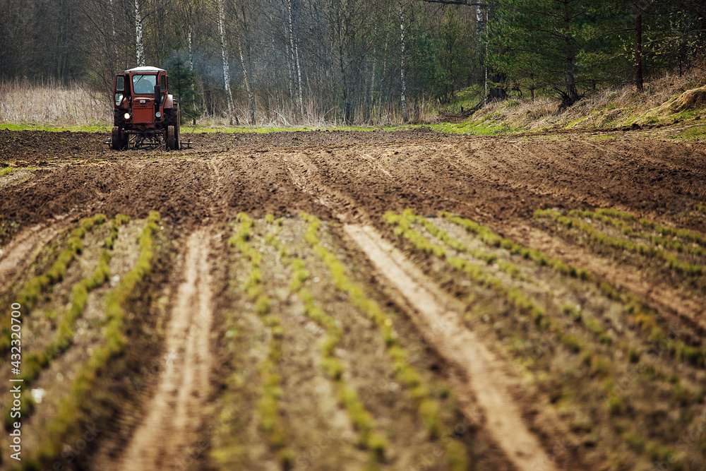 a tractor plows a field. preparation of agricultural land for planting. a mechanical plow makes furrows in the soil. cultivation of fertile land a tractor plows a field. preparation of agricultural land for planting. a mechanical plow makes furrows in the soil. cultivation of fertile land