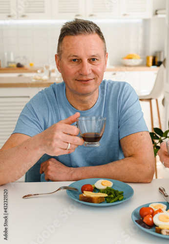 Photo of healthy senior man positive smile have dinner on the kitchen