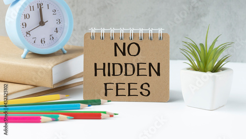 NO HIDDEN FEES written on a white background near the pen, glasses and calculator. Financial concept