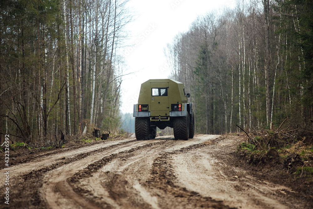 a four-wheel drive all-terrain vehicle drives through the forest through the mud. a passable SUV with large wheels and high clearance. special transport for foresters rides through swamps and mud a four-wheel drive all-terrain vehicle drives through the forest through the mud. a passable SUV with large wheels and high clearance. special transport for foresters rides through swamps and mud