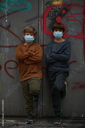 Two boys brothers with medical protection masks on the face